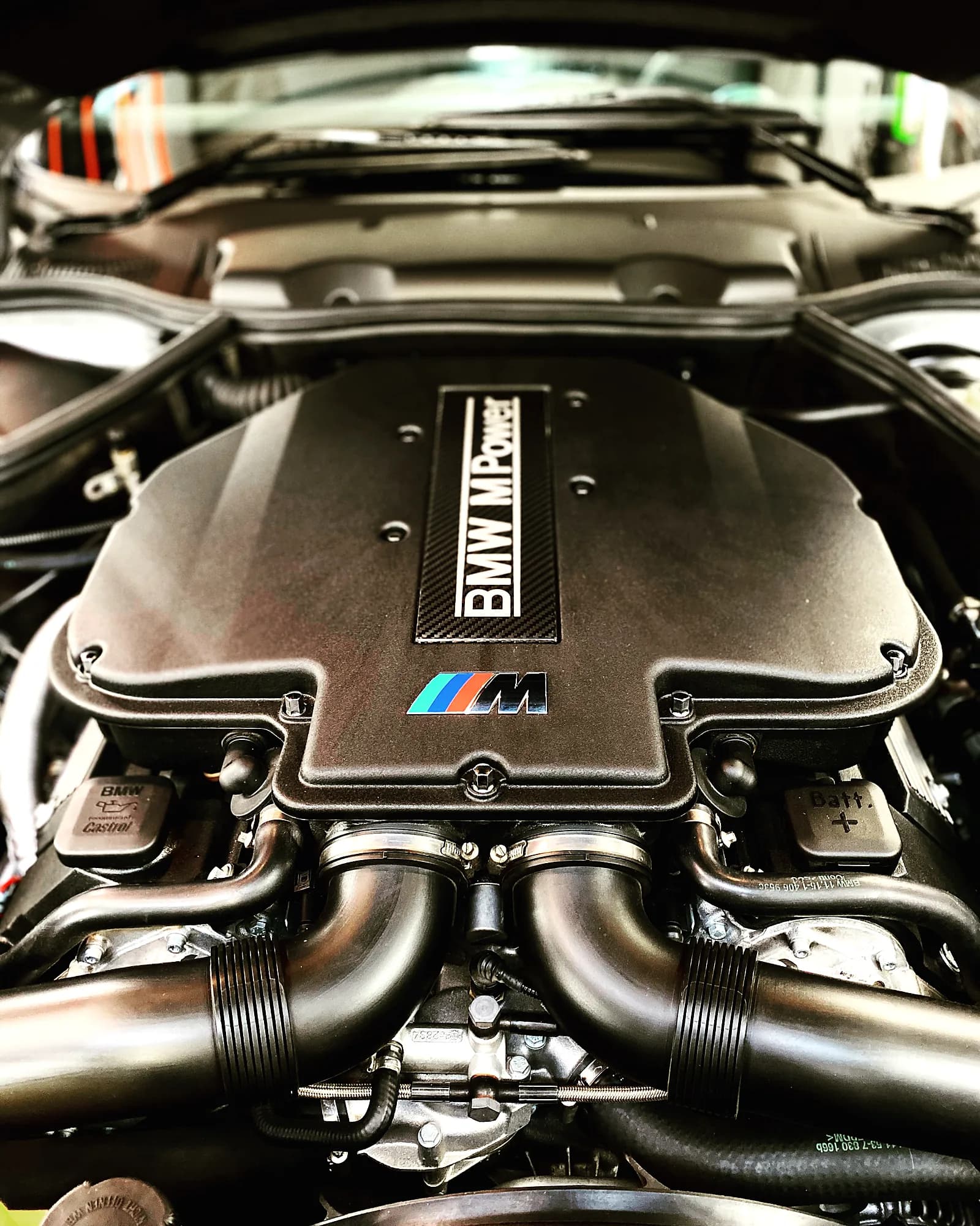 Freigelegter BMW M-Power V10-Motorraum in der Werkstatt, atmosphaerisch beleuchtet