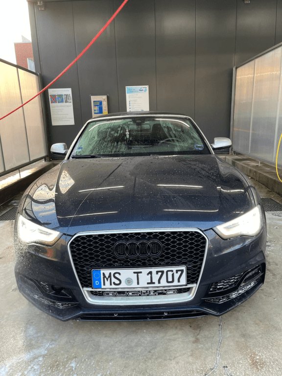 Dunkler Audi A3 Frontansicht auf dem Waschplatz.