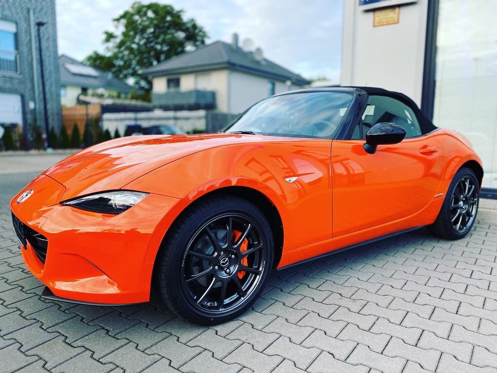 Oranger Mazda MX-5 Roadster im Showcase-Shot.