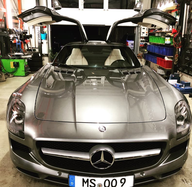 Mercedes SLS AMG mit geöffneten Flügeltüren.