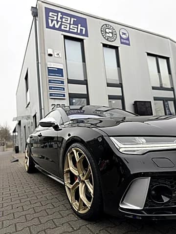 Audi RS7 mit Goldfelgen vor StarWash-Schild