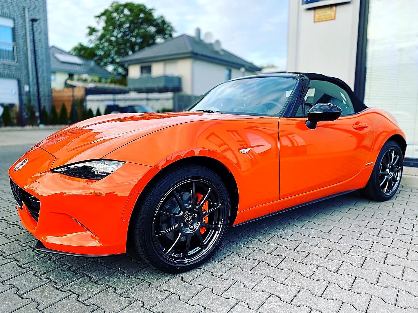 Oranger Mazda MX-5 Roadster Frontansicht auf Hof