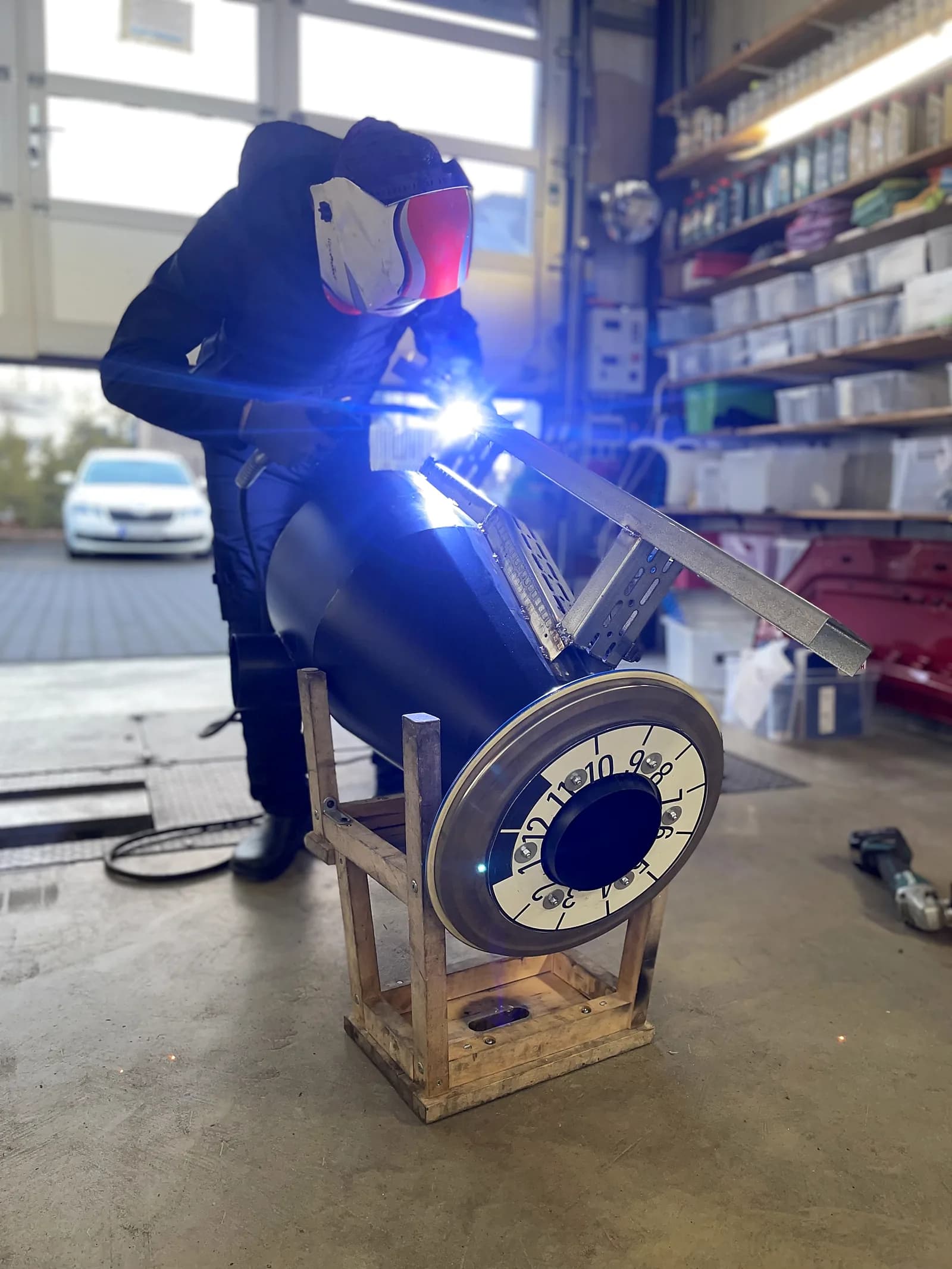 Mechaniker schweißt mit Schweißmaske und sichtbarem Funkenflug